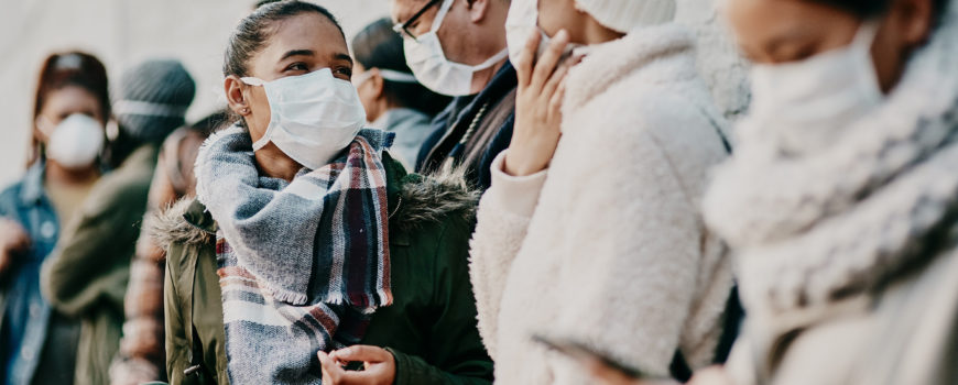 Shot of a young man and woman wearing masks while travelling in a foreign city